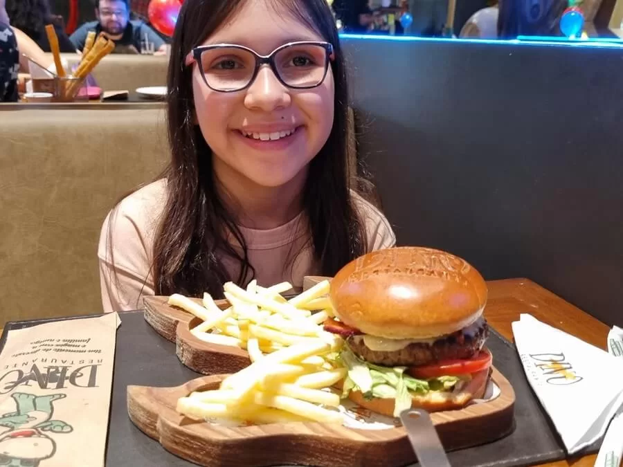 Alice escolheu o hamburger no Dino Restaurante