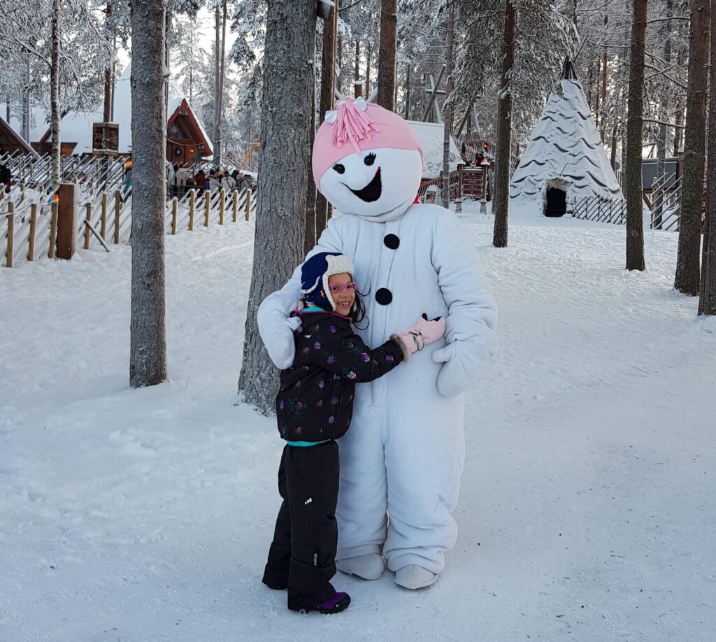 Na Aldeia do Papai Noel, as crianças se divertem na neve